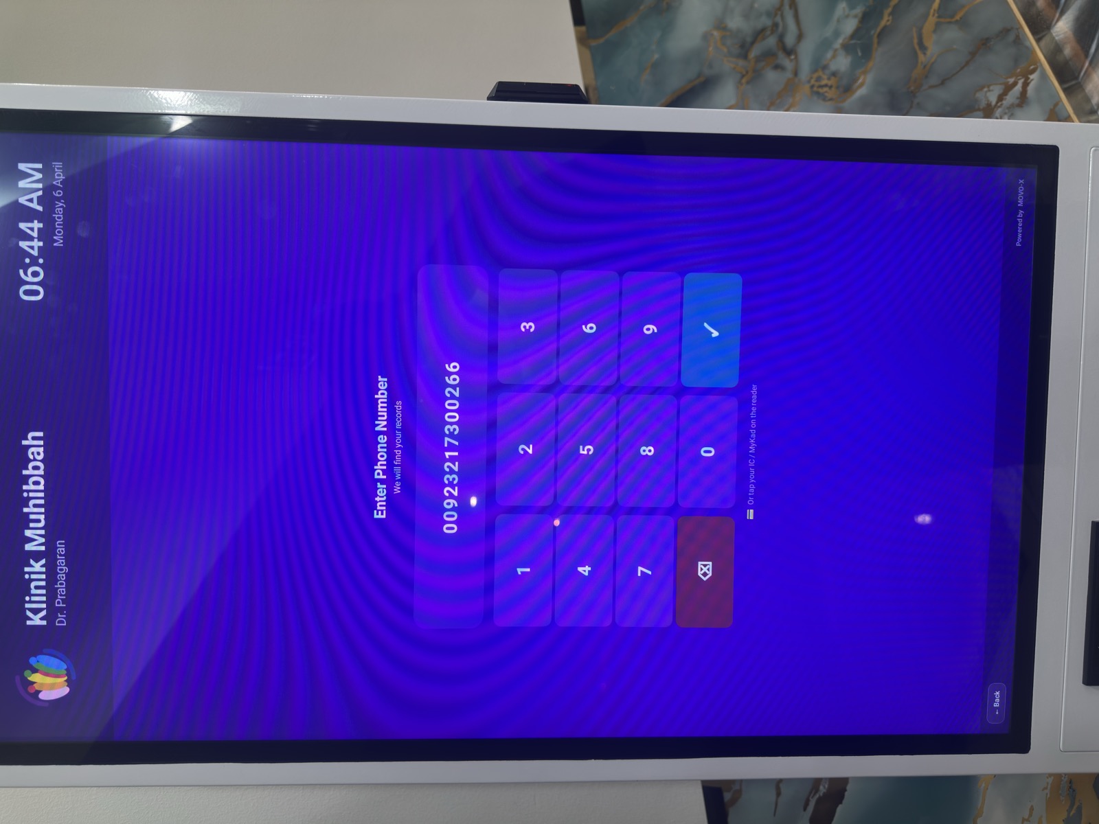 MoVo-X kiosk back panel against marble wall at Klinik Muhibbah