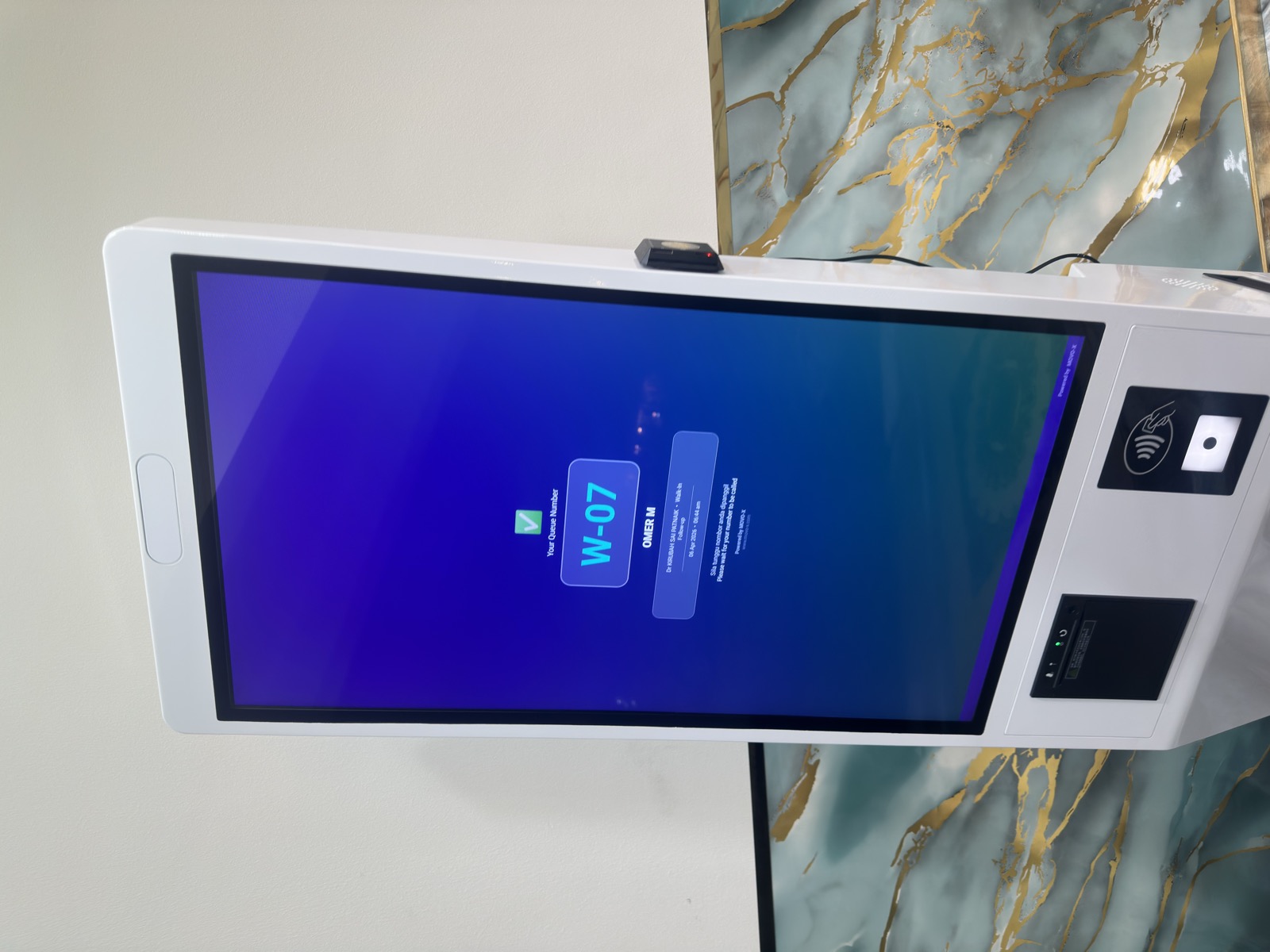 MoVo-X kiosk displaying W-07 queue ticket at Klinik Muhibbah