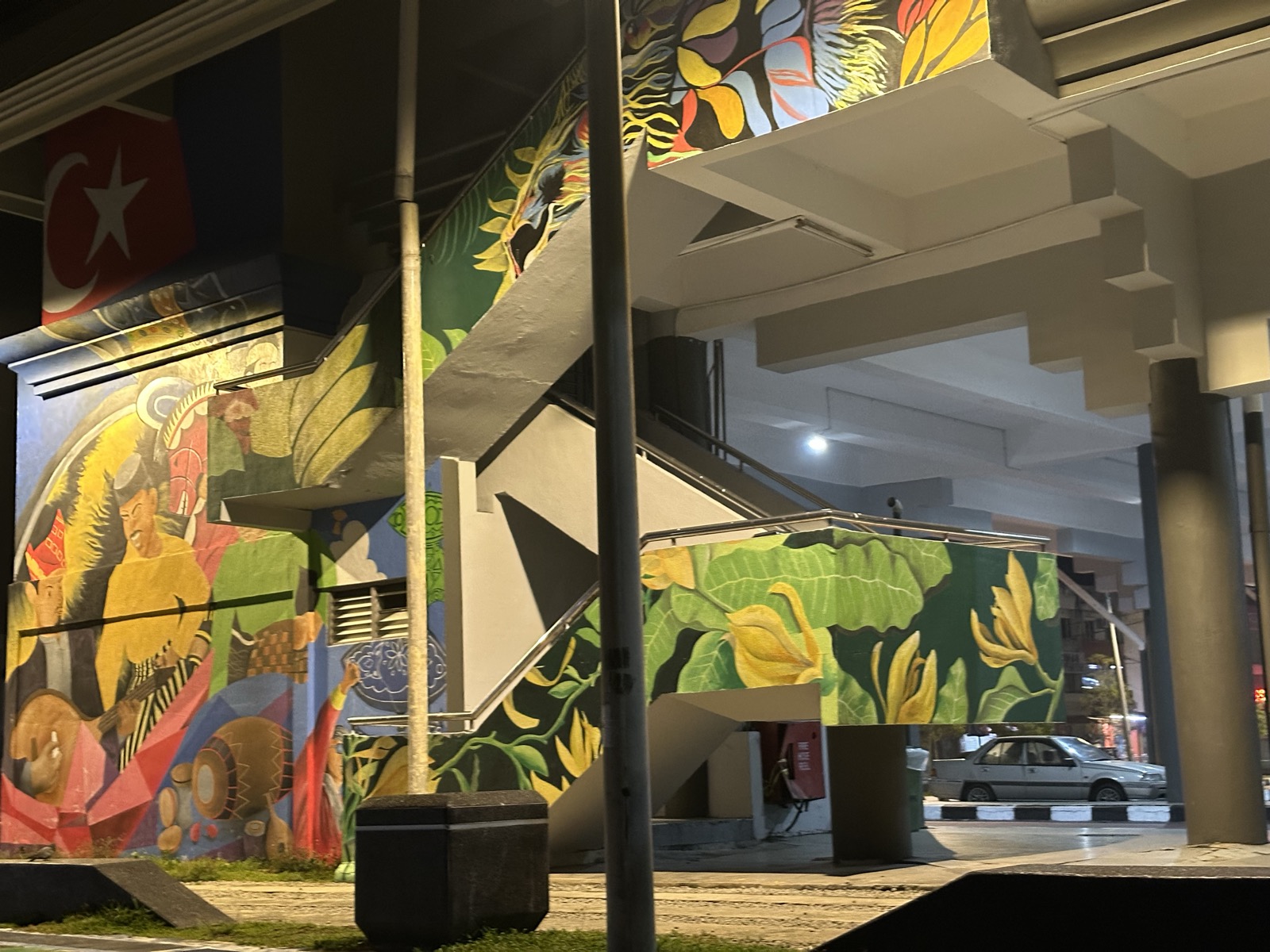 Street mural under JB overpass — tropical birds, jungle leaves, geometric shapes