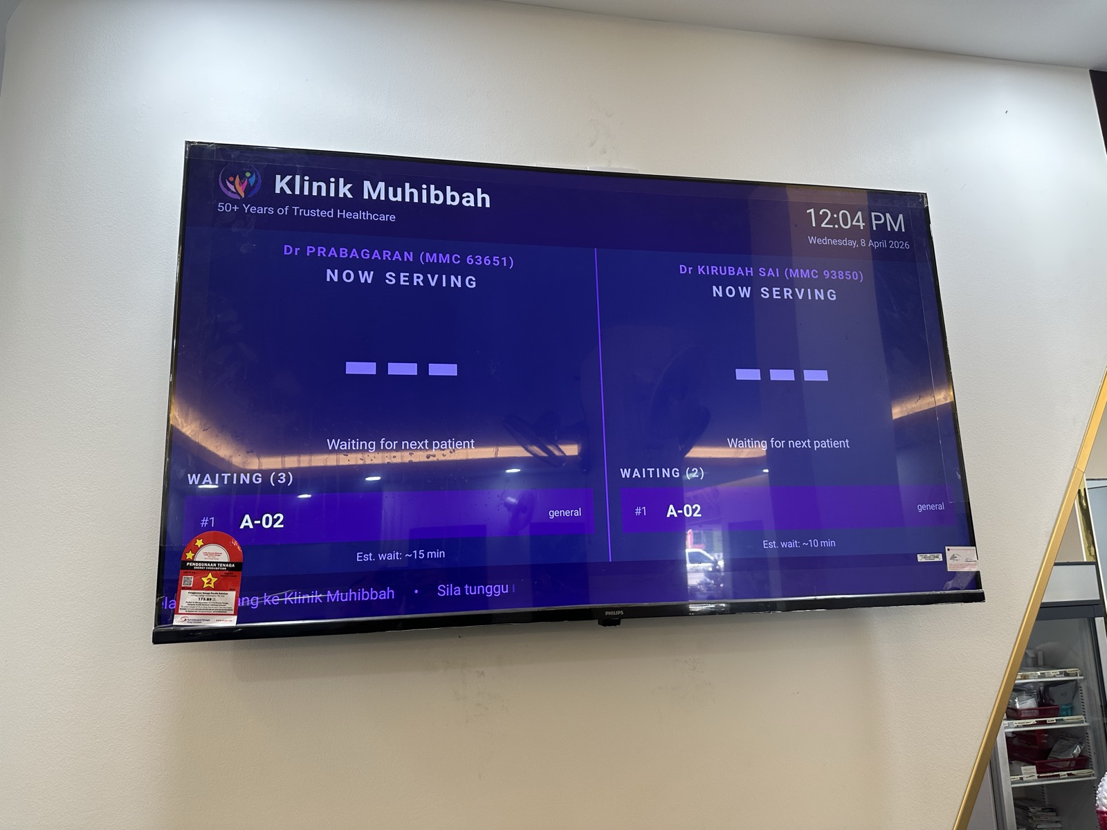 Queue display TV at Klinik Muhibbah showing two doctors and waiting patients with estimated wait times
