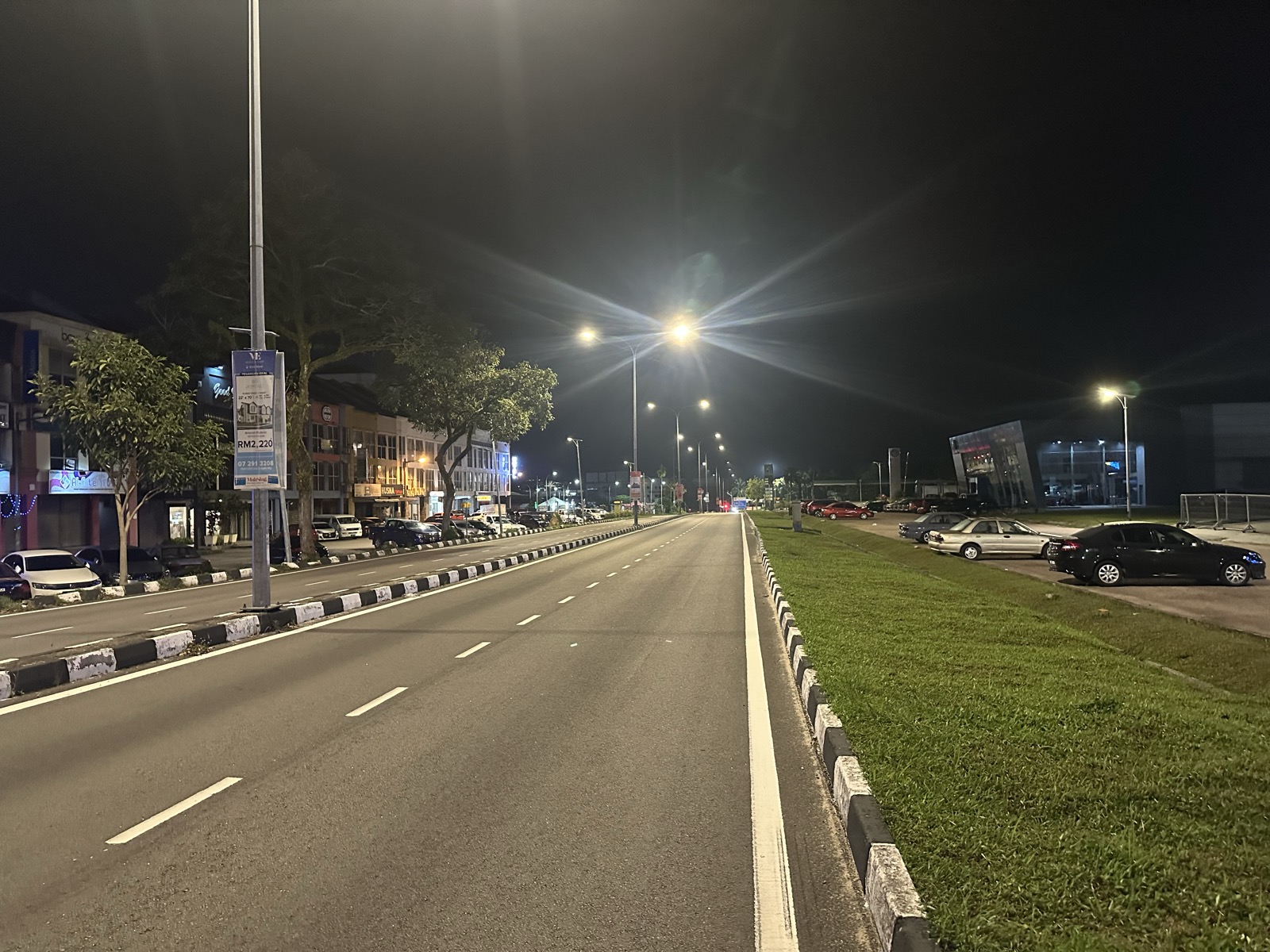Empty JB highway at night — red traffic lights, street lamps, no cars