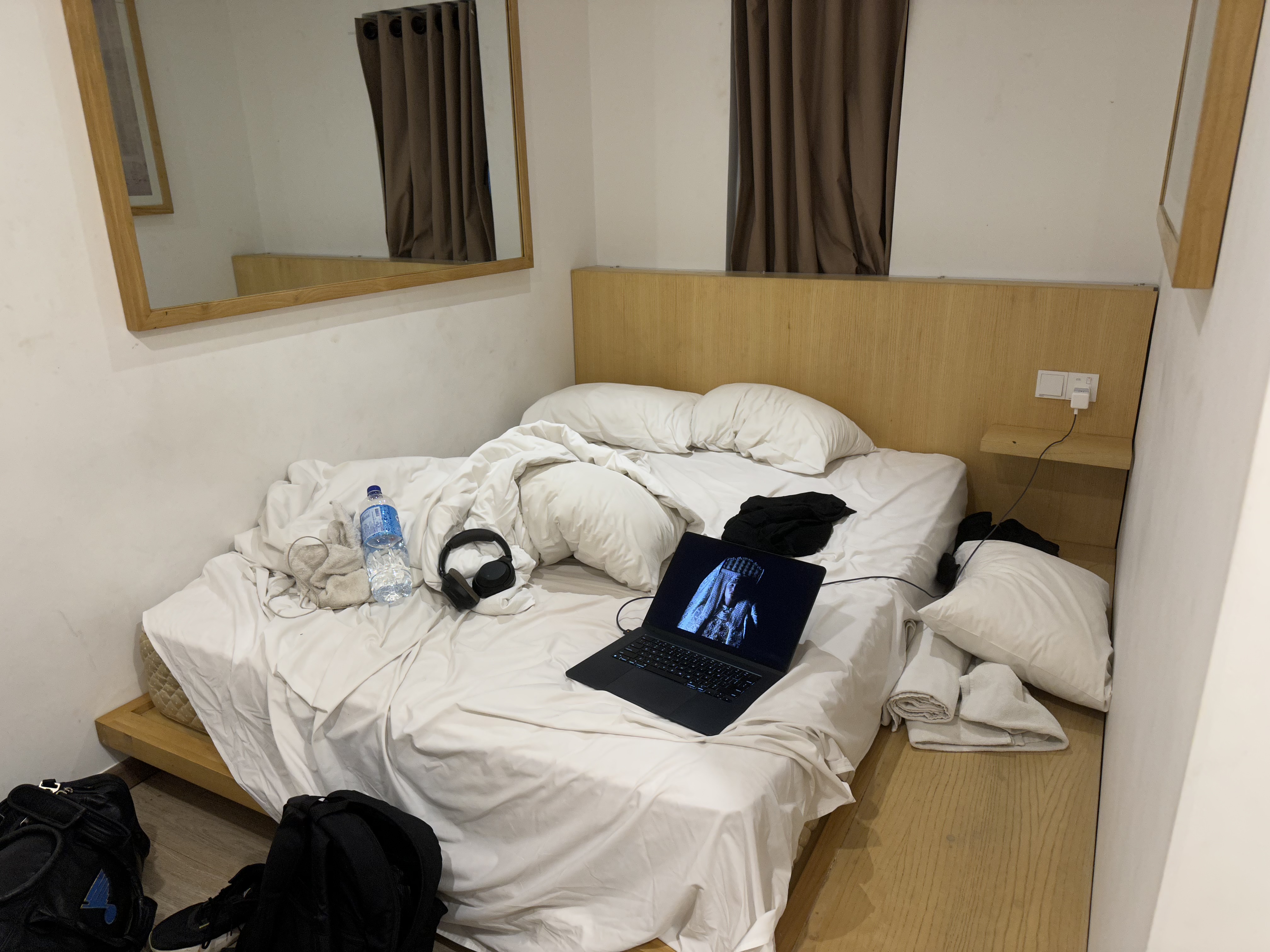 Hotel room with laptop on unmade bed — the solo traveler's creative studio