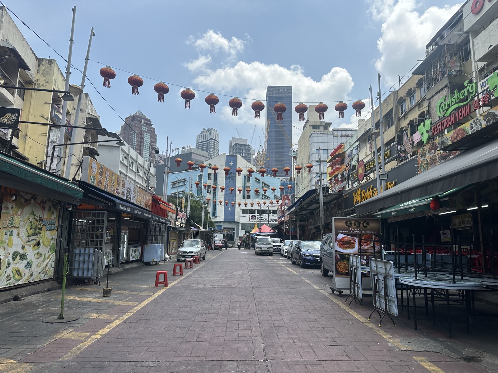 Petaling Street perpendicular — red lanterns, KLCC towers visible at far end — KL Chinatown