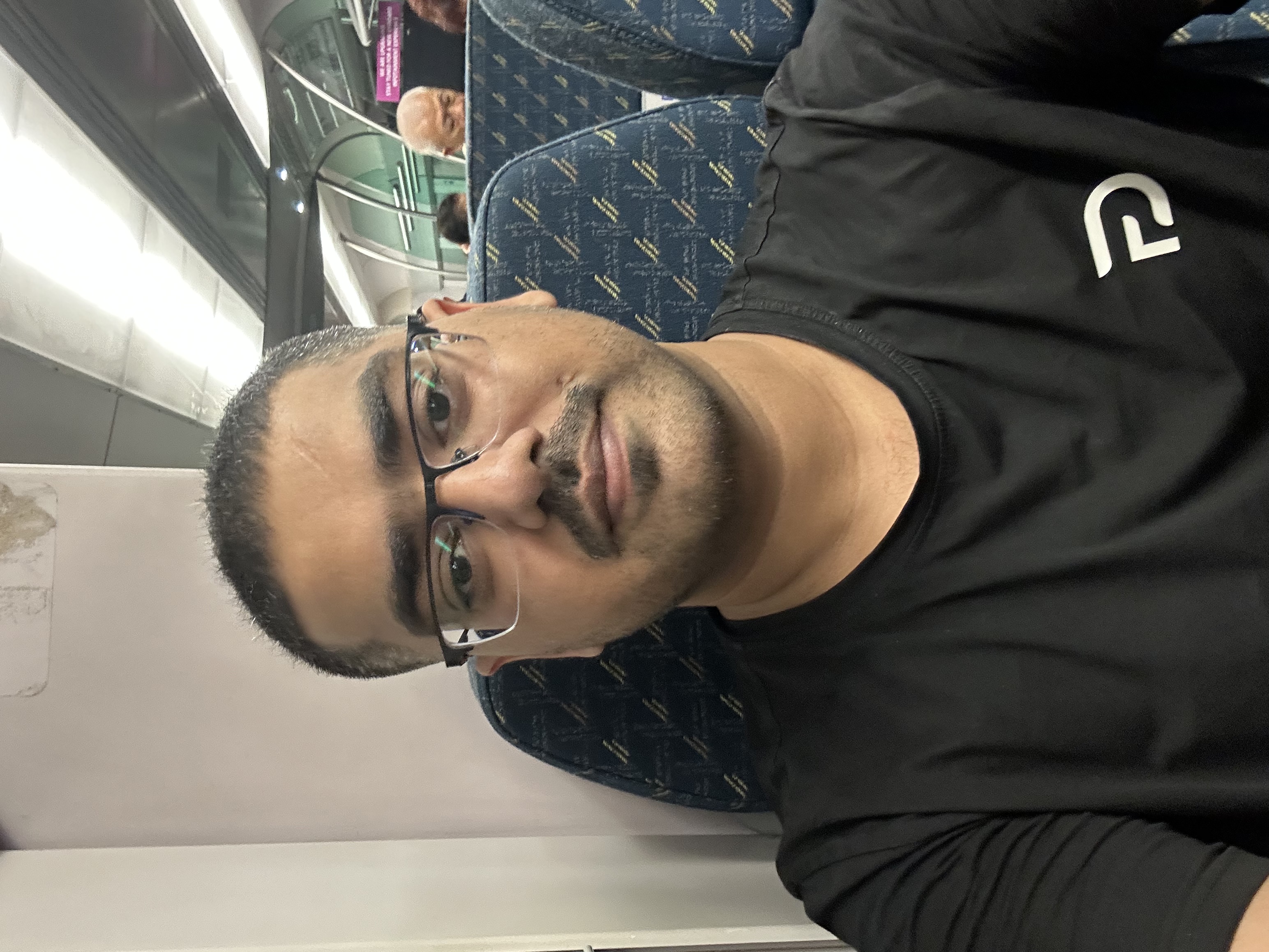 Selfie on KLIA Ekspres train — fresh haircut, black tee, glasses
