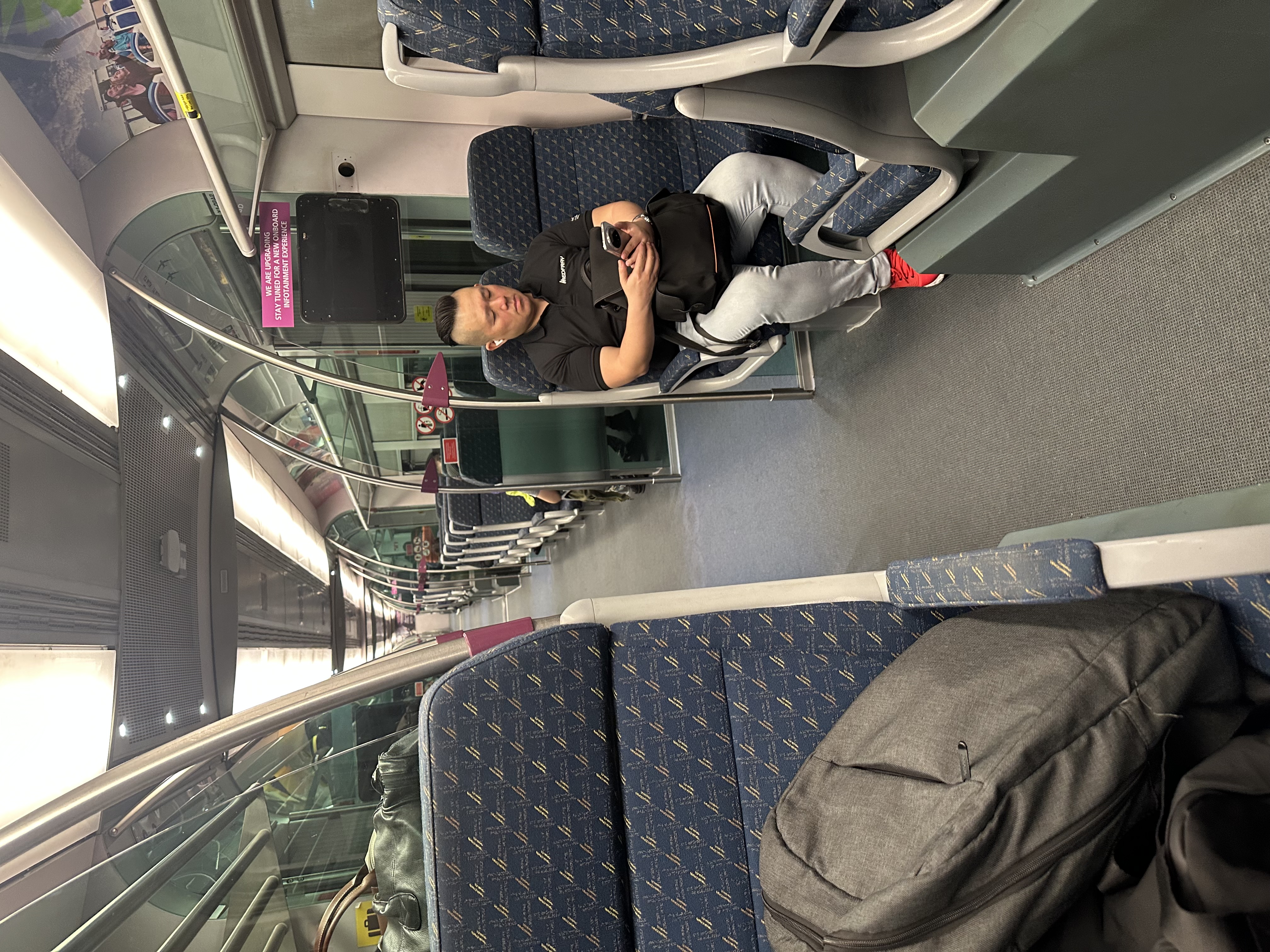 Sleeping passenger on KLIA Ekspres — red shoes, backpack, early morning