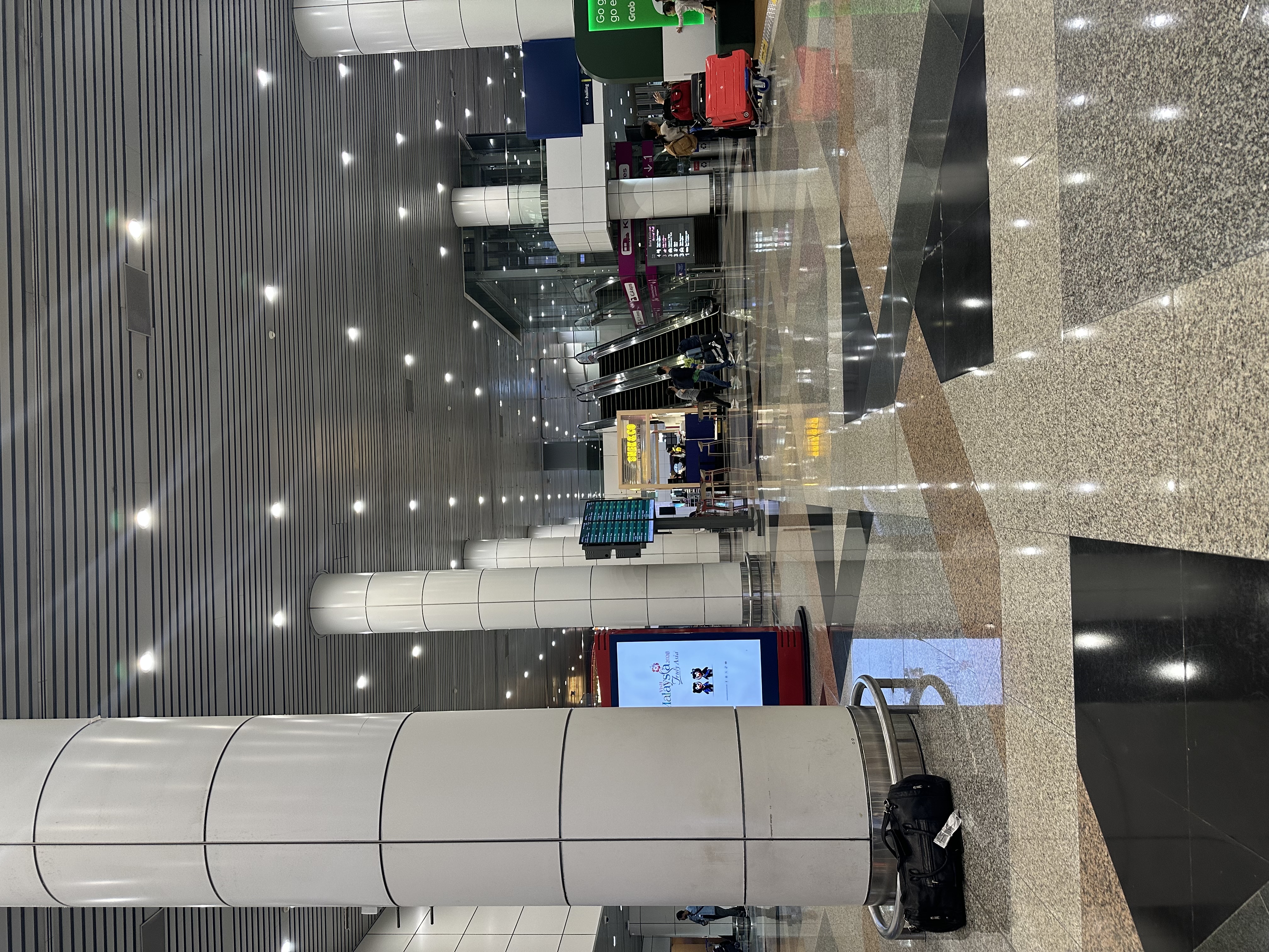 KLIA2 arrivals hall — marble floors, silver columns, spotlights — Day 5 waiting for Haadi