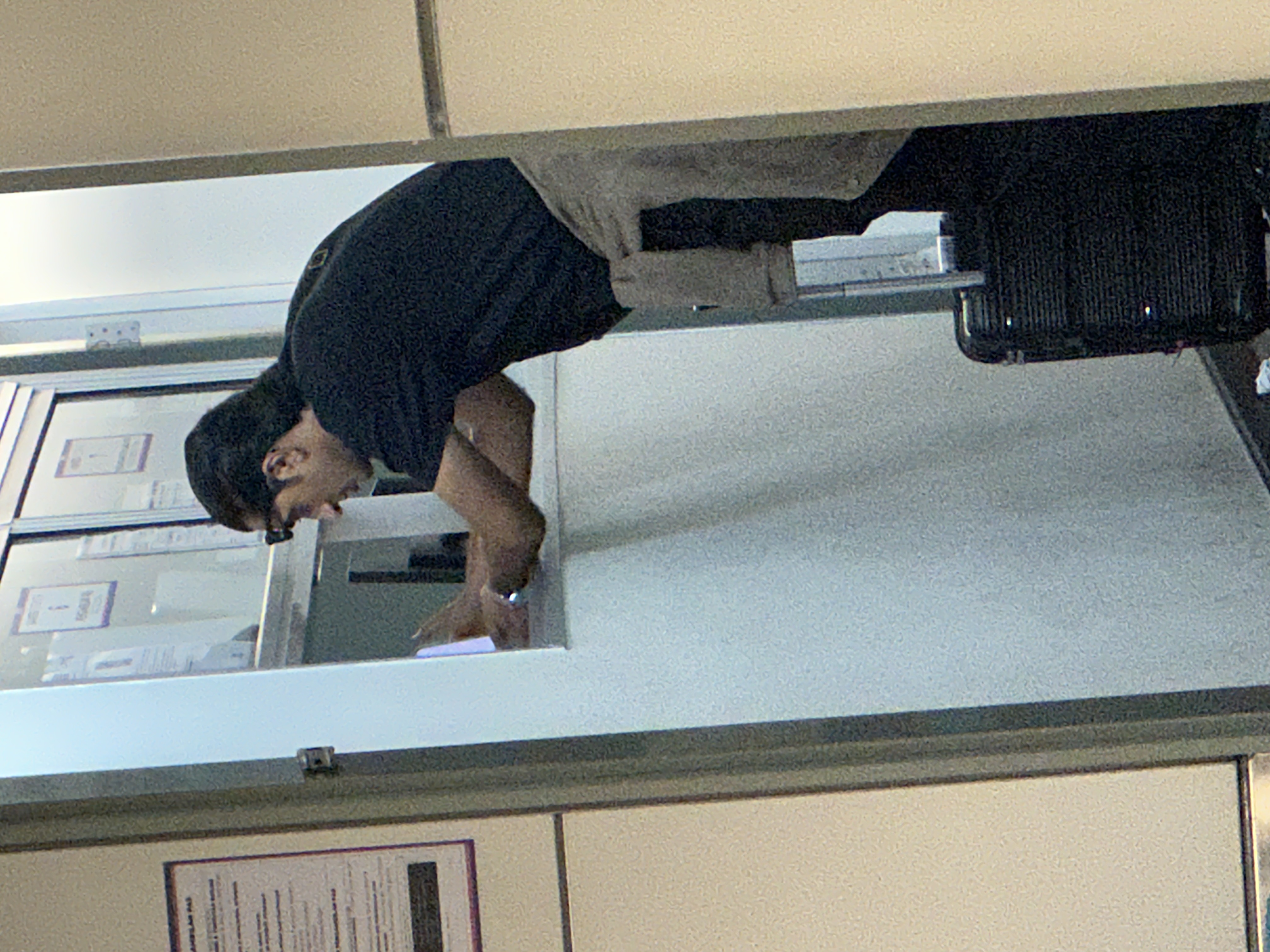 Haadi at the counter retrieving wallet