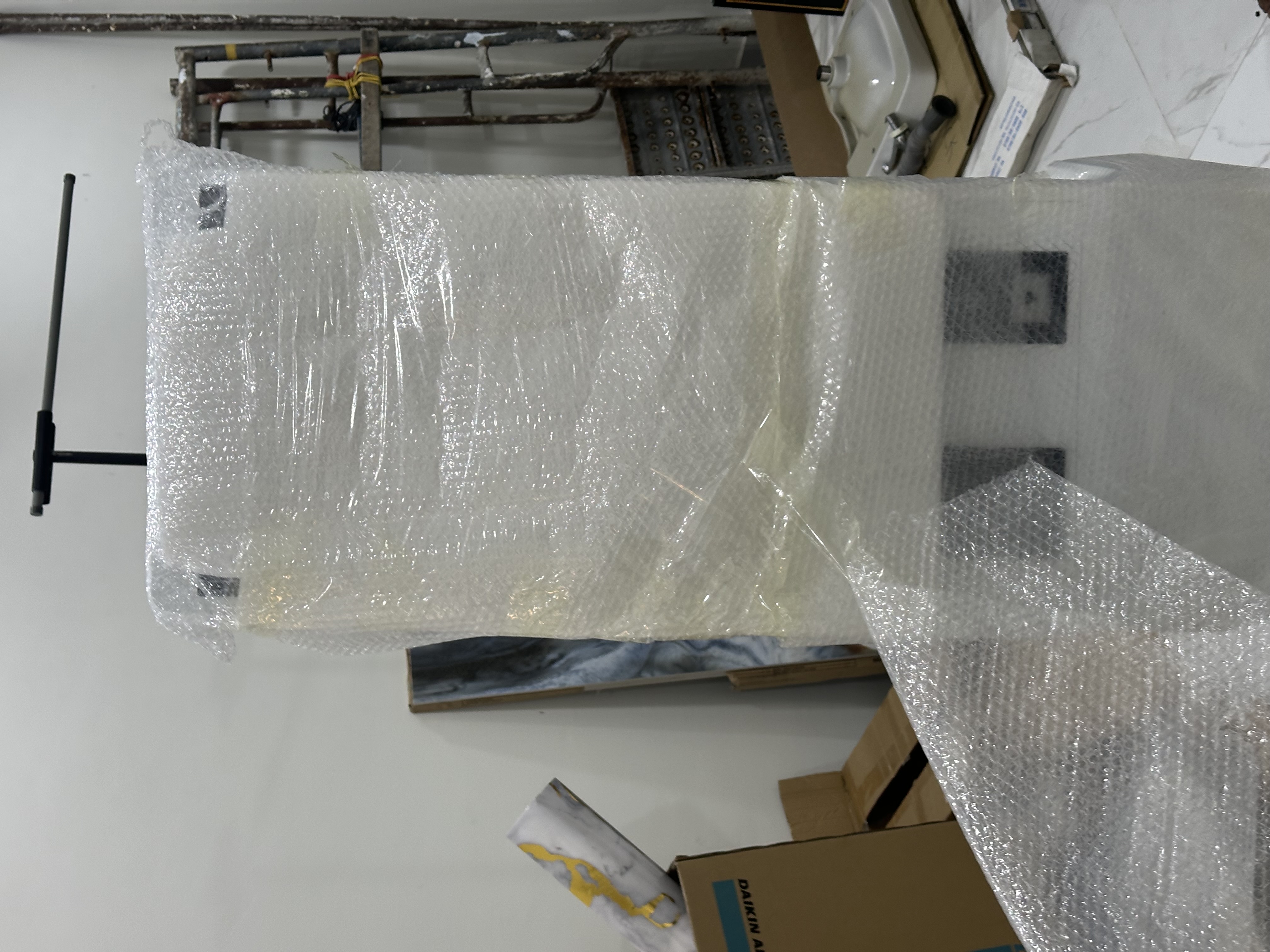 MoVo-X kiosk in bubble wrap at Klinik Muhibbah — just arrived from China
