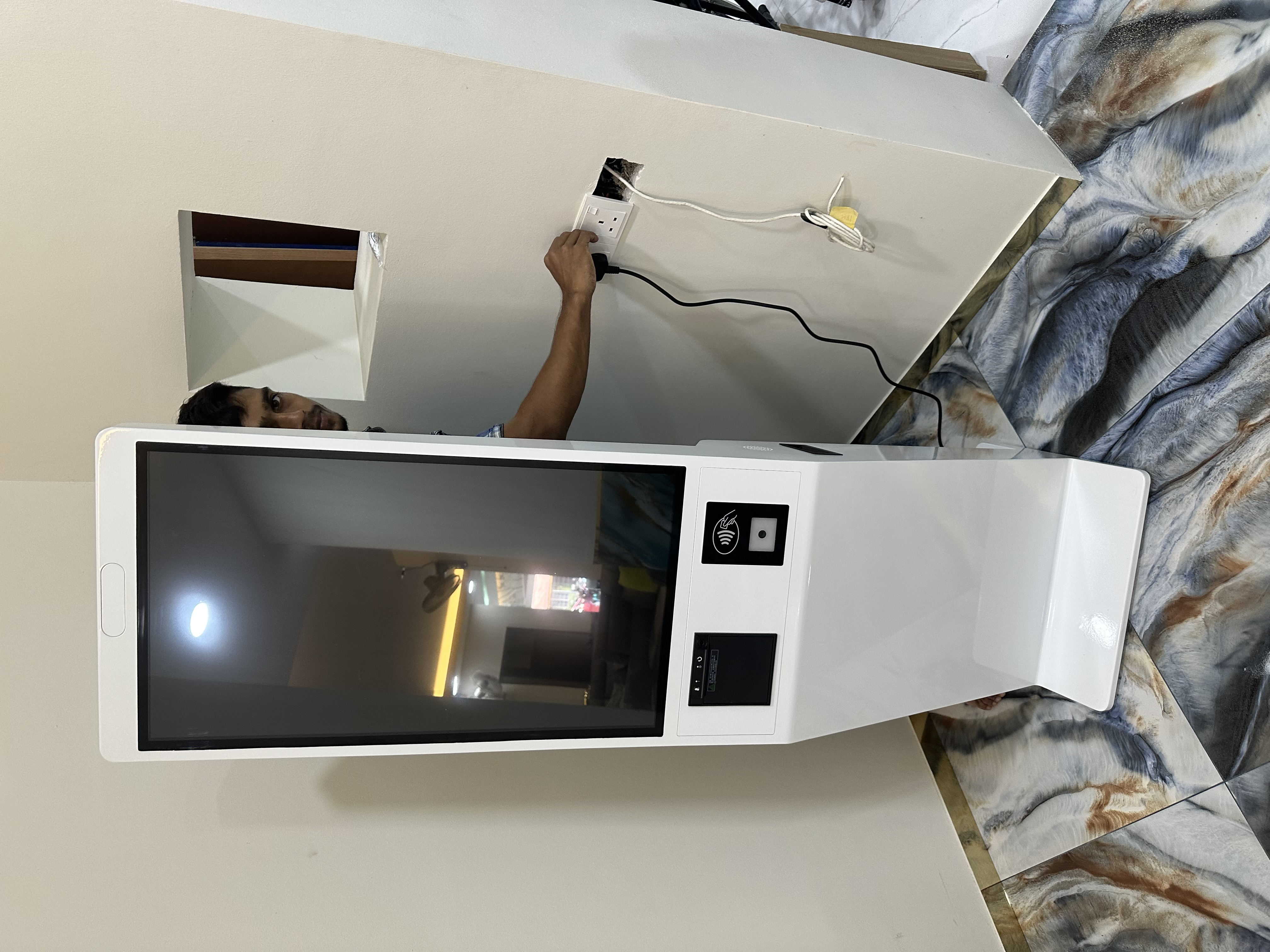 CEO Haadi plugging in the MoVo-X kiosk — first power at Klinik Muhibbah