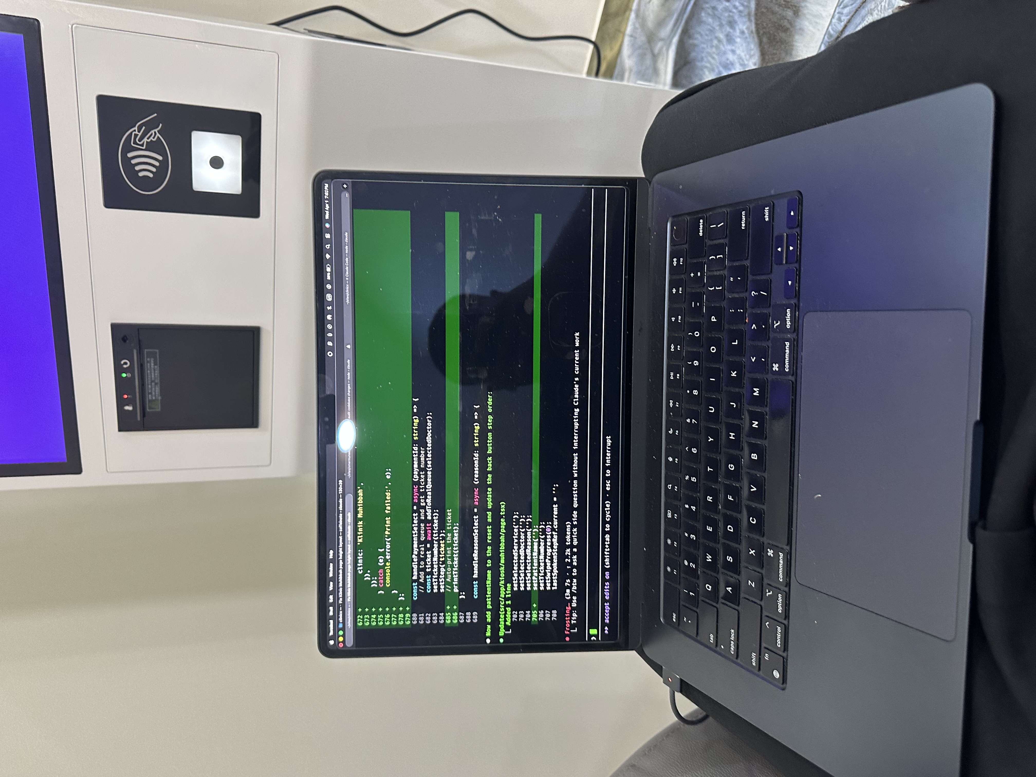 MacBook terminal debugging next to MoVo-X kiosk
