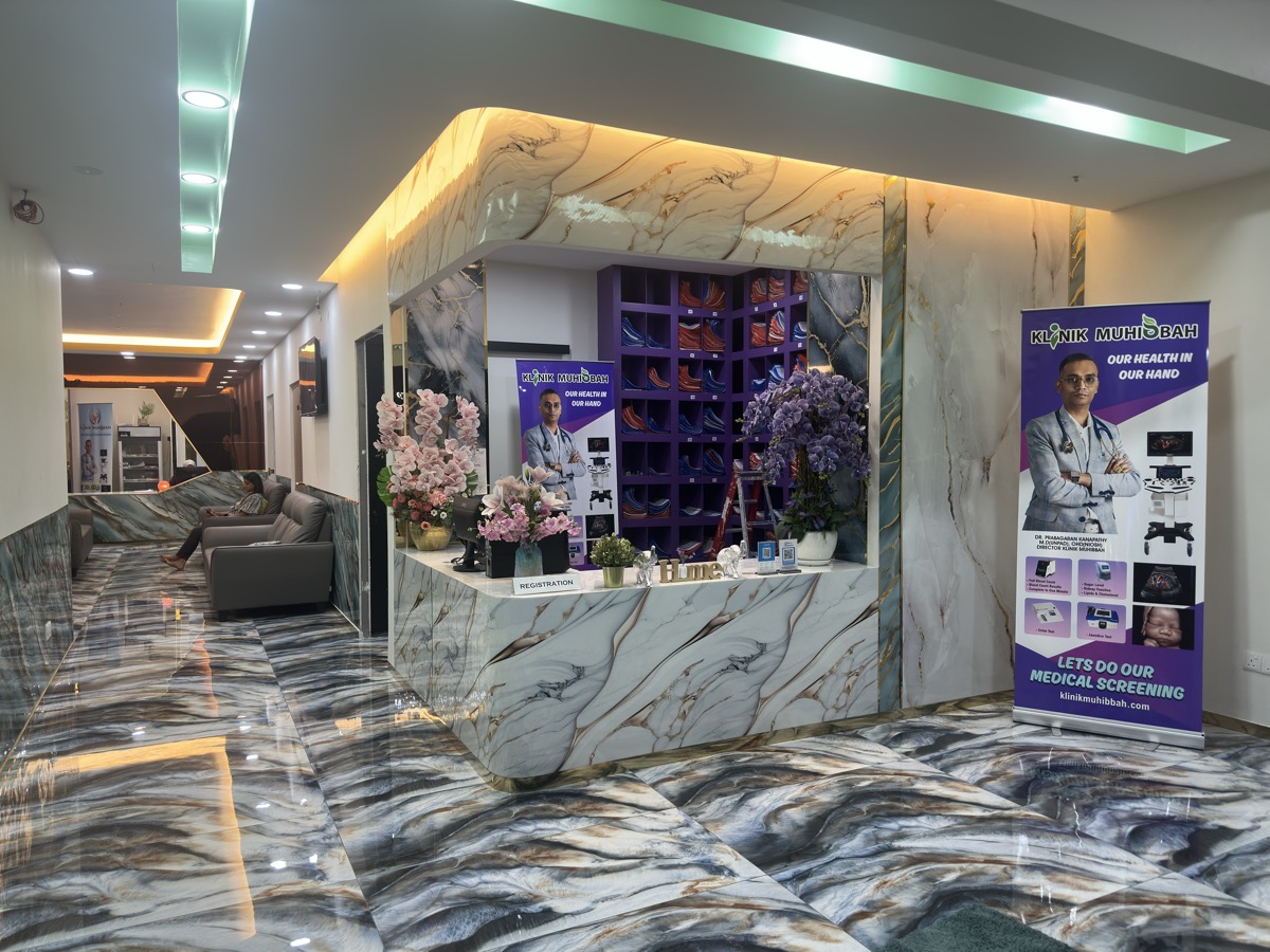 Klinik Muhibbah reception — marble, flowers, medical screening