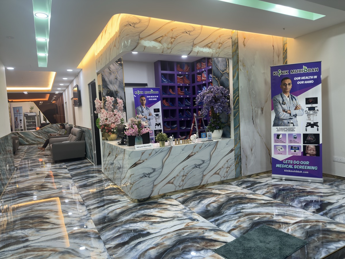 Klinik Muhibbah lobby — marble floors, flowers, Dr. Prabha banners