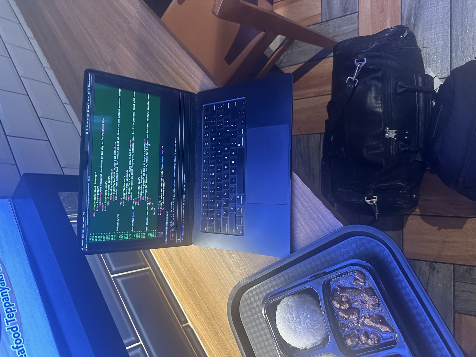 MacBook open with Claude Code at teppanyaki